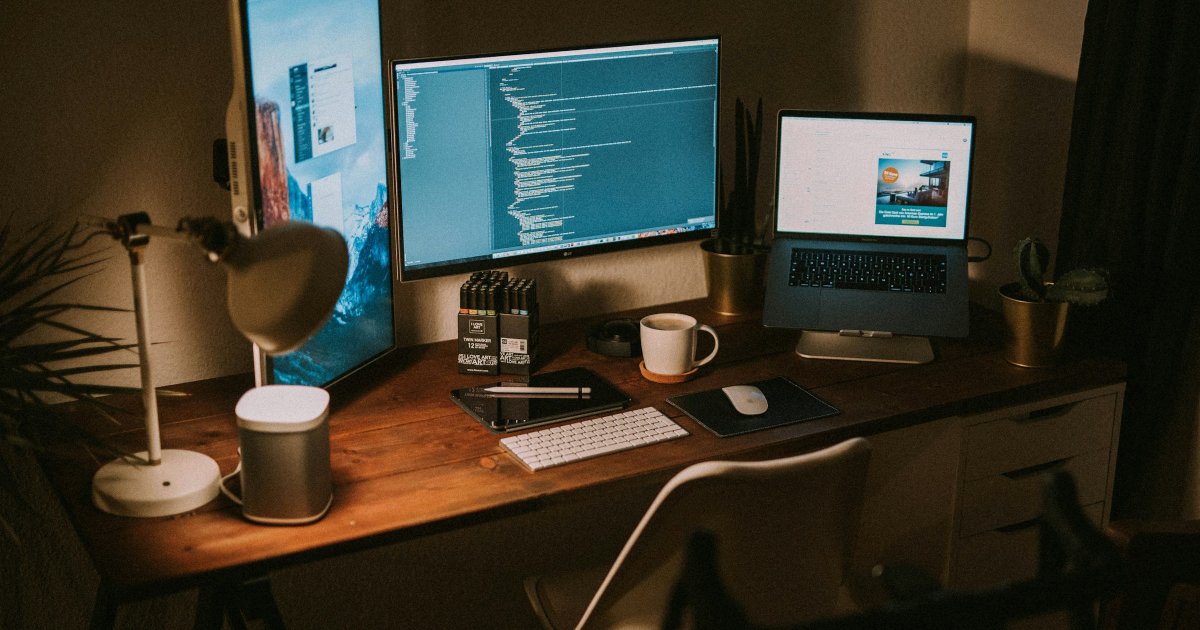 Ergonomic desk setup with a wooden desk, white chair, and natural lighting in a cozy home office